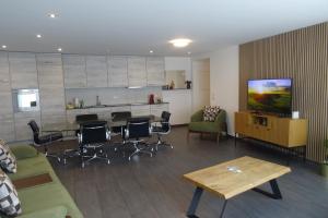 a living room with a table and chairs and a tv at The Golf apartments in Interlaken