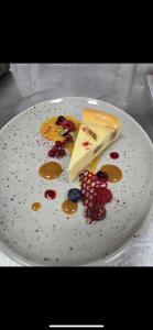 a white plate with a piece of cheesecake on it at Four Points by Sheraton Budapest Danube in Budapest