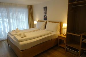 a bedroom with a bed with two teddy bears on it at The Golf apartments in Interlaken +51 photos