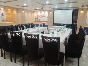a meeting room with a long table with chairs and a screen at Hotel Rahul Deluxe in Nagpur
