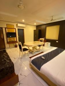 a room with a desk and a table and a table and chairs at Hotel Rahul Deluxe in Nagpur