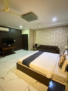 a large bedroom with a large bed and a desk at Hotel Rahul Deluxe in Nagpur