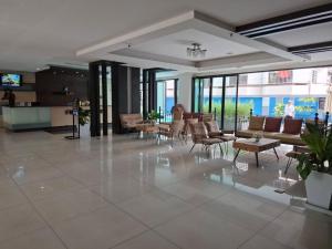 a large lobby with chairs and tables and windows at Vogue Pattaya Hotel in Pattaya