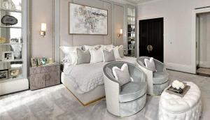 a white bedroom with a large bed and two chairs at Kos blue & green in Kos