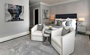 a bedroom with a bed and two chairs and a table at Kos blue & green in Kos +3 photos