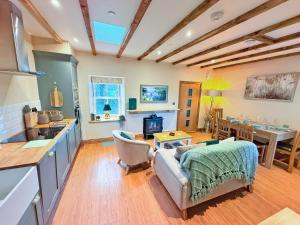 a kitchen and living room with a couch and a table at Bumblebee Cottage-Uk39918 in Ballakinnag