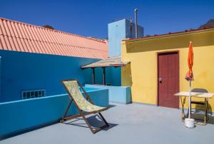 a patio with a chair and a table and a building at Quinta Toca do leão in Ribeira Grande