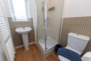 a bathroom with a shower and a toilet and a sink at Vantage Stays in Gloucestershire +15 photos