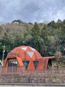 a house with an orange roof on top of a hill at ゲストハウスフォレ in Kukumo