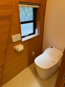 a small bathroom with a toilet and a window at ゲストハウスフォレ in Kukumo +34 photos