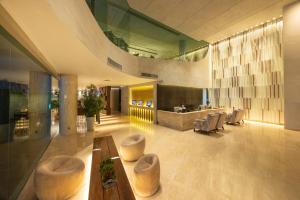 a lobby of a building with tables and chairs at LiT BANGKOK Hotel in Bangkok