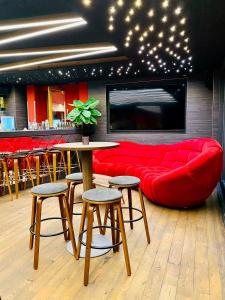 a living room with a red couch and a table and stools at Hotel Credé in Kassel
