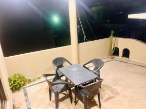 a table and chairs on a balcony at night at Mohib Home Stay in Lahore