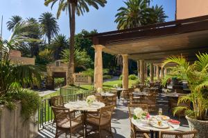 an outdoor patio with tables and chairs and a fireplace at Santa Catalina, a Royal Hideaway Hotel - Gran Lujo in Las Palmas de Gran Canaria