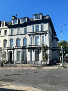 a large white building on the corner of a street at Austens Apartments in Torquay