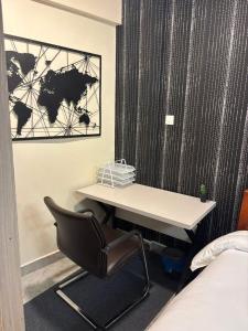 a desk in a room with a chair next to a bed at Sitati in Ruaka