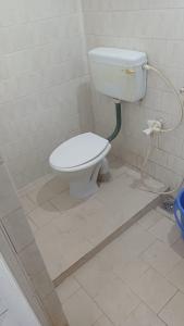 a bathroom with a white toilet in a room at Ganga Homestays in Tiruvannāmalai