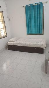 a bed in a room with a blue curtain at Ganga Homestays in Tiruvannāmalai