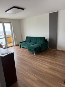 a living room with a green couch in an apartment at UniqueView Apartament Jana Pawła in Białystok