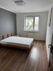 a bedroom with a bed and a window at UniqueView Apartament Jana Pawła in Białystok