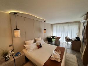 a bedroom with a large bed and a living room at Hôtel Eve Cap d'agde Village Naturiste in Cap d'Agde +142 photos