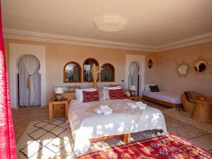 a bedroom with a large bed and a couch at Les Jardins de la Santé in Tamazouzte