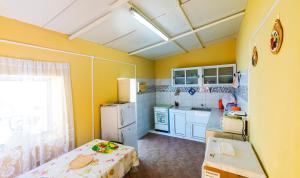 a small kitchen with yellow walls and white appliances at Quinta Toca do leão in Ribeira Grande