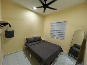 a bedroom with a bed and a ceiling fan at Homestay D'Kampong in Teluk Intan