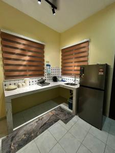 a kitchen with a refrigerator and two sinks in it at Homestay D'Kampong in Teluk Intan