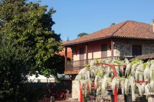 a house with a fence and white flowers in front of it at Casa do Palheiro - Valença in Bade