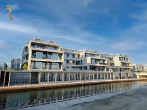 a large building next to a body of water at Cozy Poolside 1BR - Serene Luxe Chic Retreat in Abu Dhabi