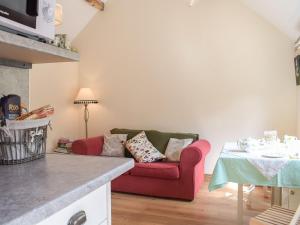 a living room with a red couch and a table at Badgers Den - Uk32084 in Dorstone