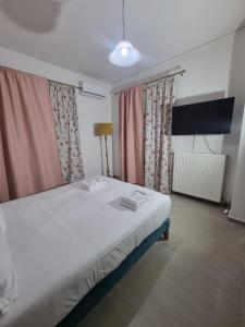 a bedroom with a white bed with pink curtains at La Campagne Ioannina Kranoula in Ioannina