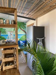 a kitchen with a refrigerator and a plant in a room at The Voyager Océan View in Port Mathurin