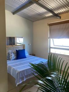 a bedroom with a blue bed and a window at The Voyager Océan View in Port Mathurin