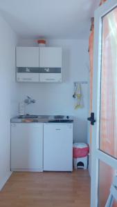 a white kitchen with a sink and a refrigerator at Studio apartment in town center in Stari Grad