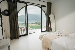 a bedroom with a bed and a view of the ocean at Glamor Kintamani in Kubupenlokan