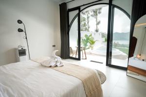 a bedroom with a bed with a view of the ocean at Glamor Kintamani in Kubupenlokan