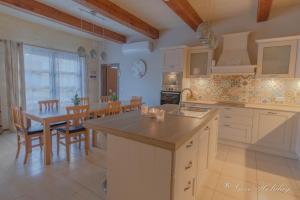 a large kitchen with a table and a dining room at Hollies in Qala +31 photos