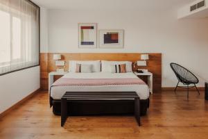 a bedroom with a large bed and a chair at Rafaelhoteles Atocha in Madrid