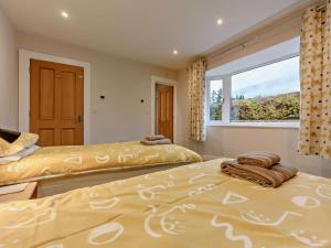 two beds in a bedroom with a window at 3 Bed in Keswick oc-93589 in Threlkeld