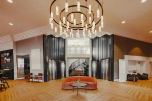 a living room with a couch and a chandelier at Rafaelhoteles Atocha in Madrid