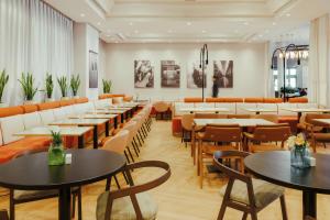 a dining room with tables and chairs and a cafeteria at Rafaelhoteles Atocha in Madrid