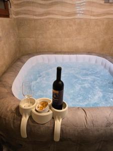 a bottle of wine and a glass in a hot tub at Kuća za odmor Velnira in Ozalj
