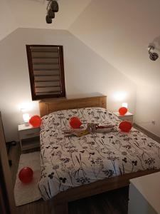 a bedroom with a bed with red spheres on it at Kuća za odmor Velnira in Ozalj