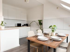 a kitchen with a wooden table and white cabinets at NEU - Gemütliches Apartment, Gruppen, Zentral in Erfurt +22 photos