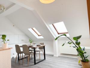 a dining room with a table and chairs and skylights at NEU - Gemütliches Apartment, Gruppen, Zentral in Erfurt