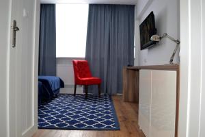 a room with a red chair and a blue rug at Błękitny Żagiel in Gdynia
