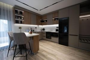 a kitchen with a white counter and a black refrigerator at Sunset Luxury Apartments in Keramoti