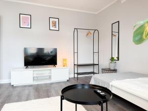a white living room with a tv and a couch at NEU - Gemütliches Apartment, Gruppen, Zentral in Erfurt